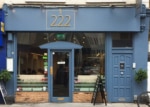 Blue restaurant facade with large windows and door.