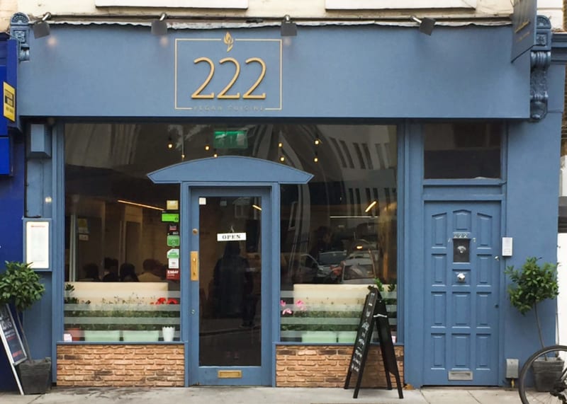 Blue restaurant facade with large windows and door.