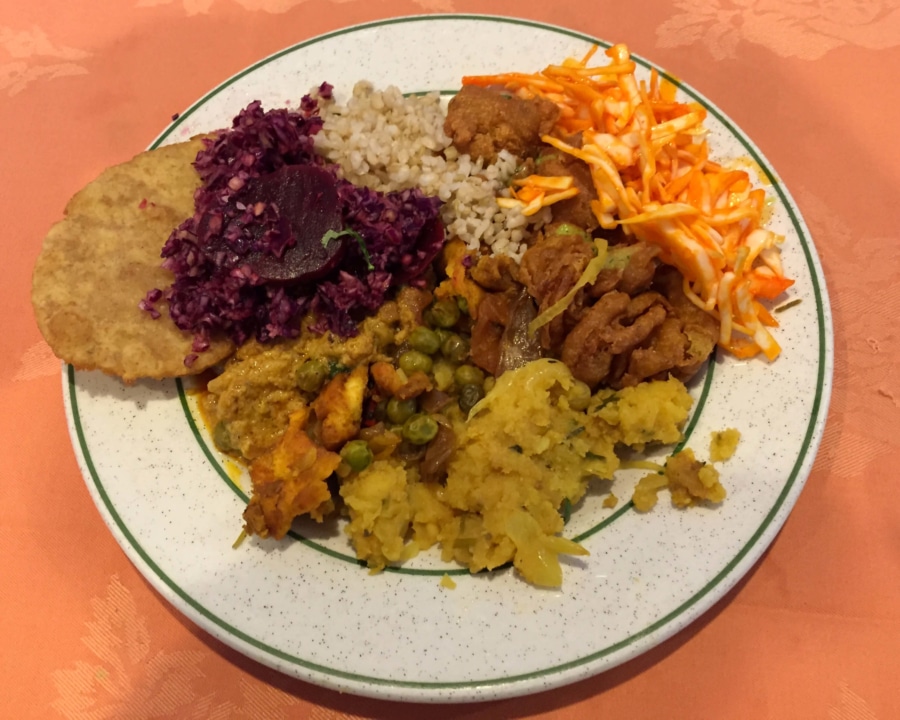 Mix of curries with rice and side salads.
