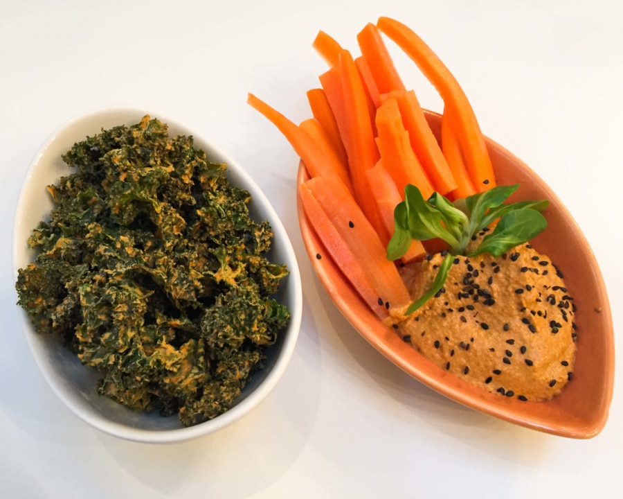 Kale chips alongside carrots with hummus dip.