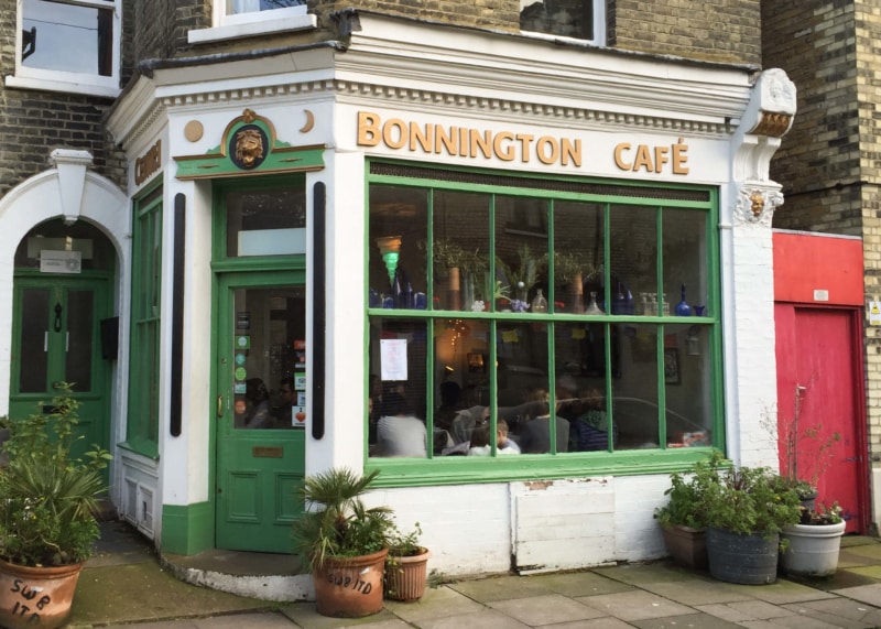 White restaurant facade with green-trimmed windows and door.