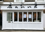 White restaurant facade with windows and door.