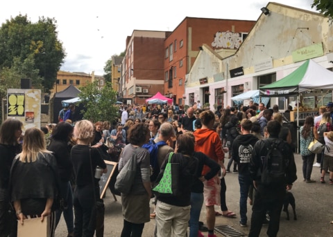 People queuing for stalls at an outdoor market.