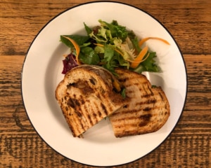 Roasted pepper, aubergine and peanut butter grilled sandwich with salad.