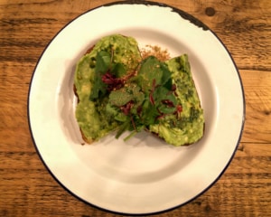 Avocado on toast topped with salad.